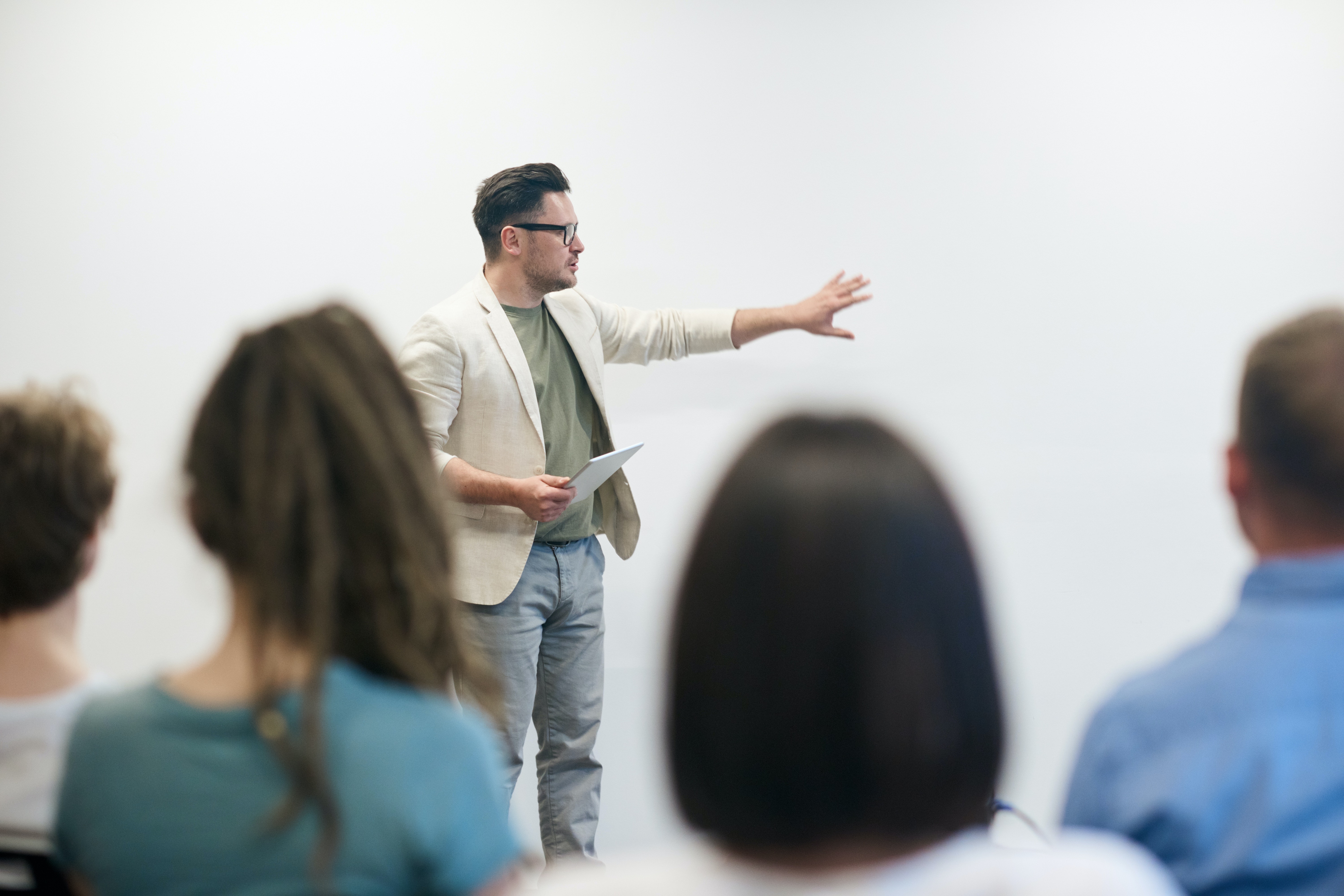 Man in blazer instructs university classroom