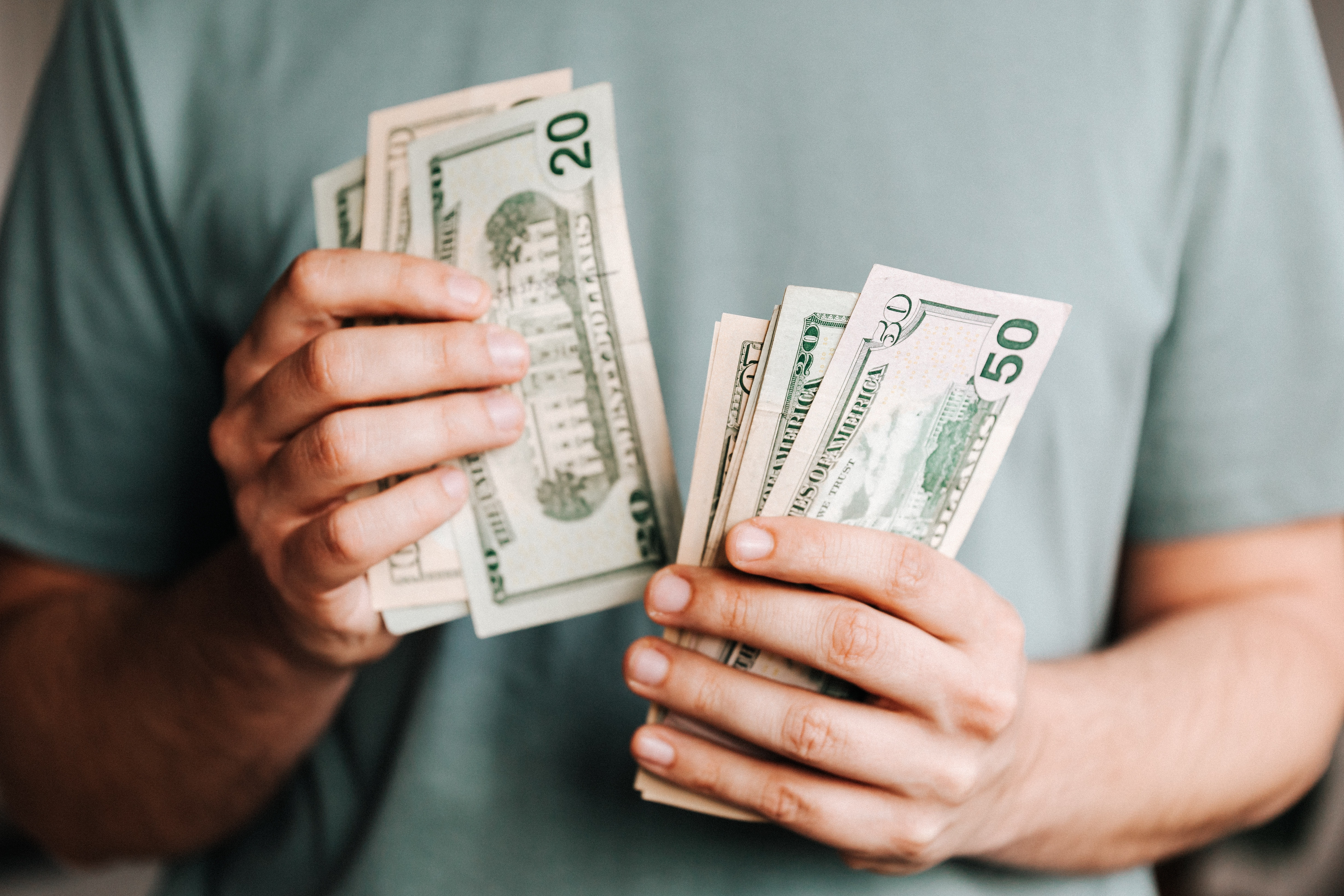 Close up on person holding multiple dollar bills