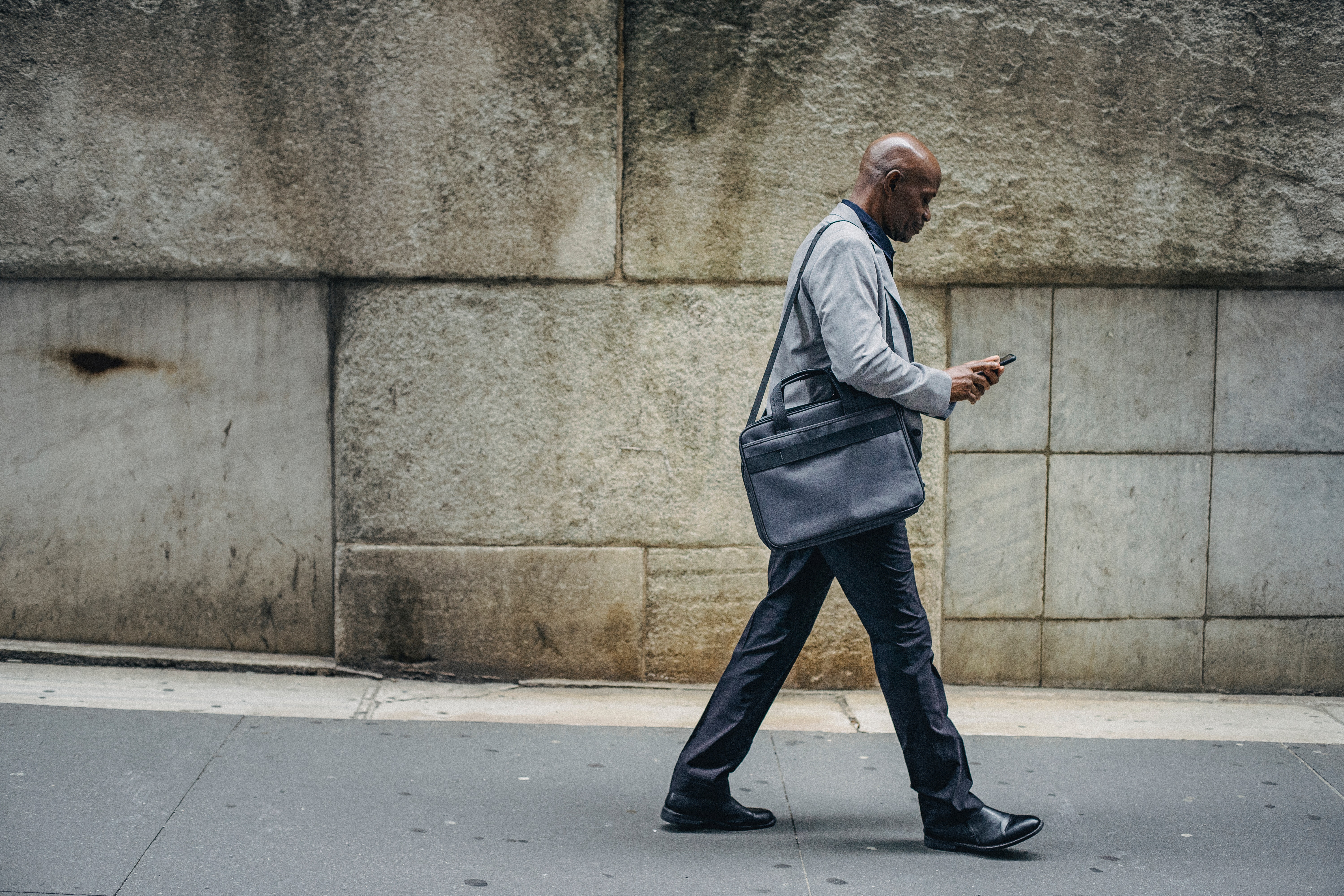 Busy black manager looks at mobile phone