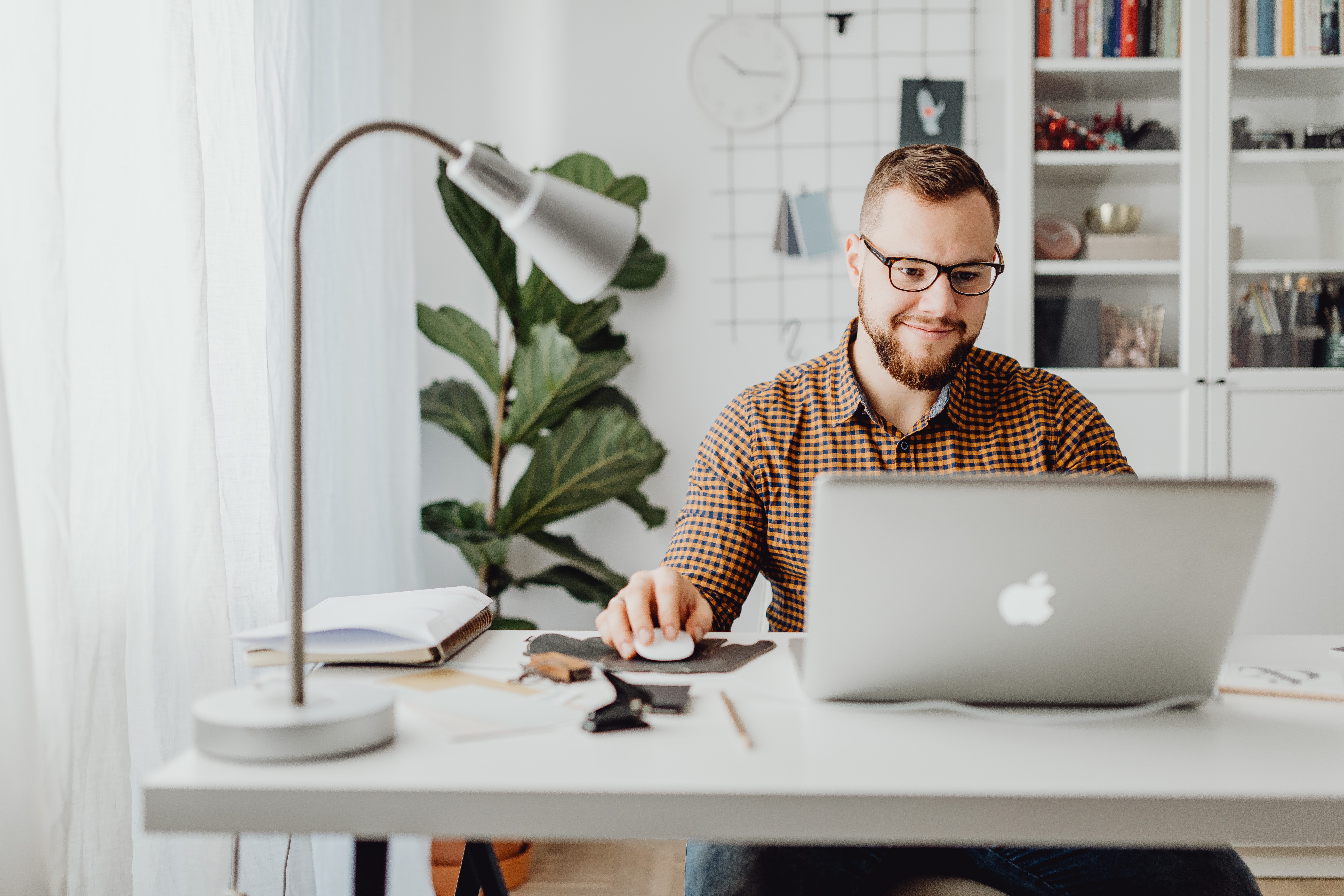 Man sits at his desk and works on his laptop