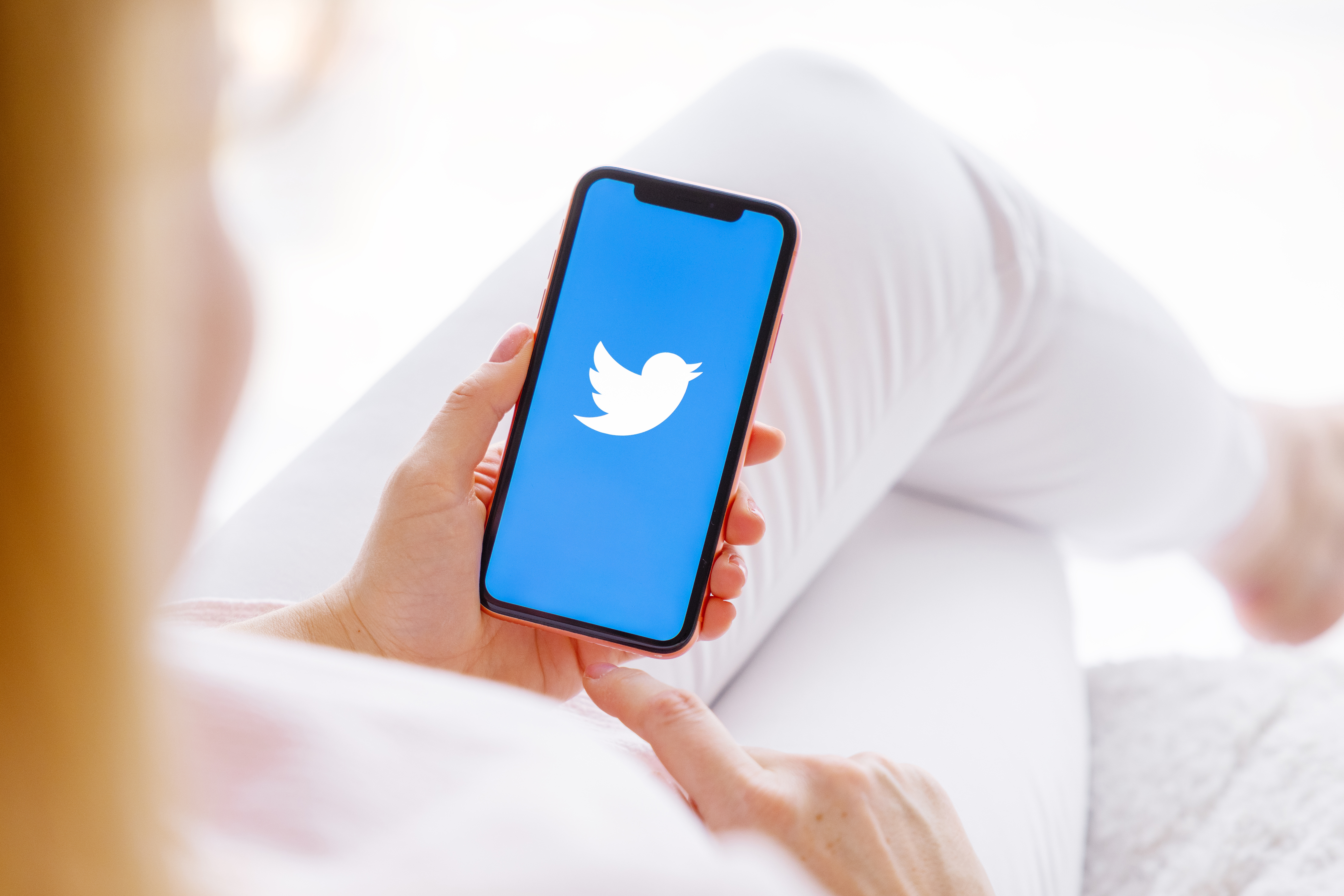 woman uses mobile smart phone to log onto Twitter