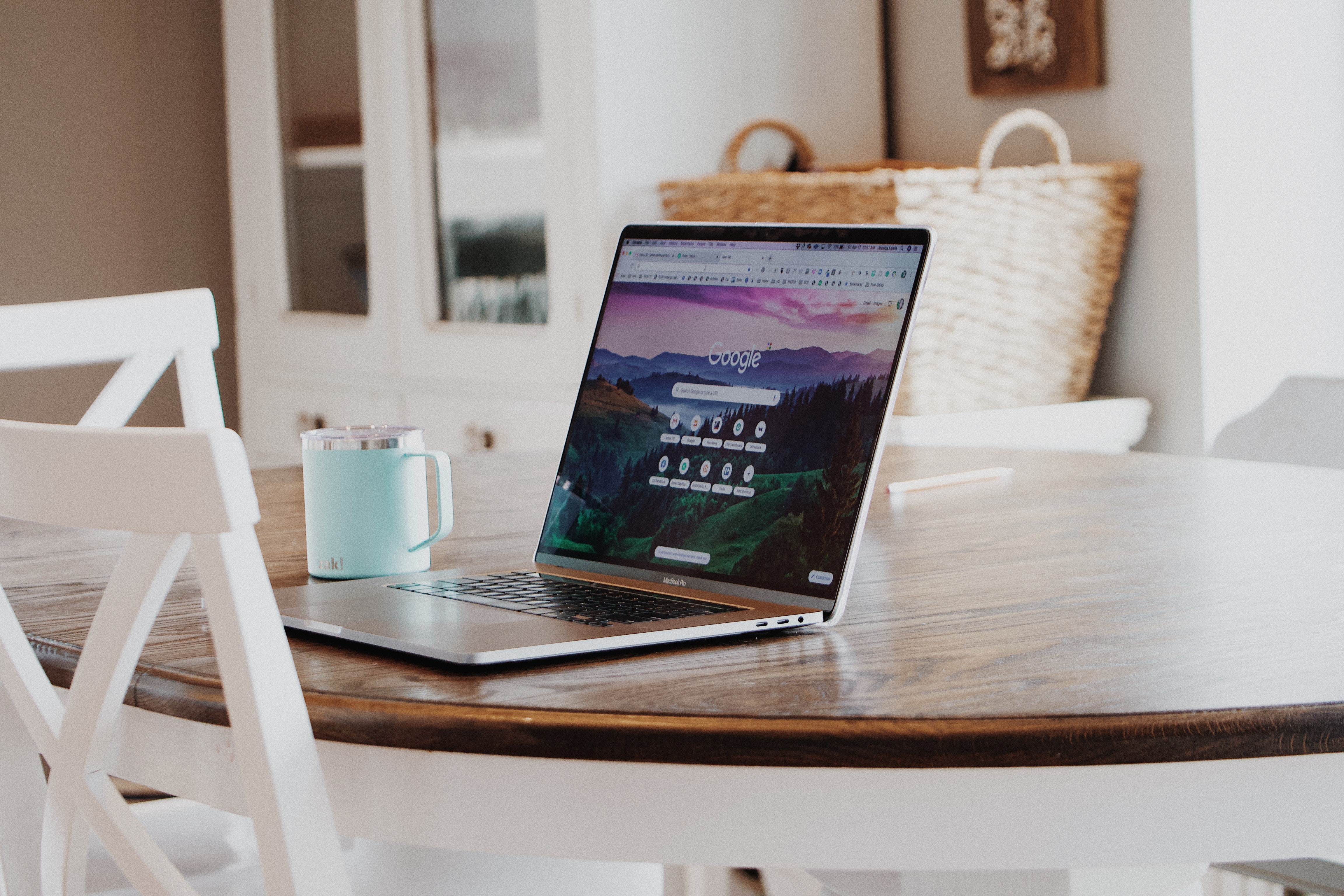 Apple Mac laptop sits open to google on a kitchen table