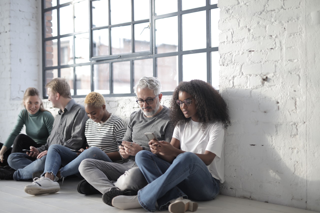 Diverse group of people engage with each other and their mobile phones