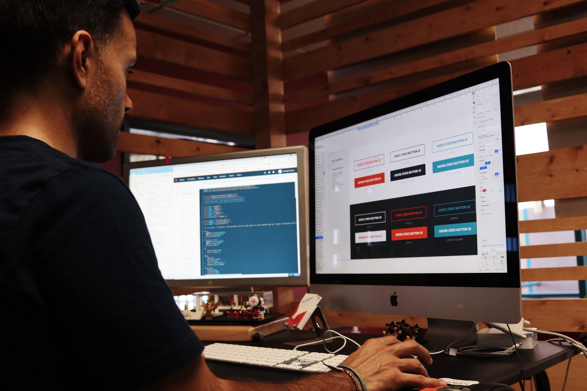 Man working on a computer with two monitors editing web design and development tools