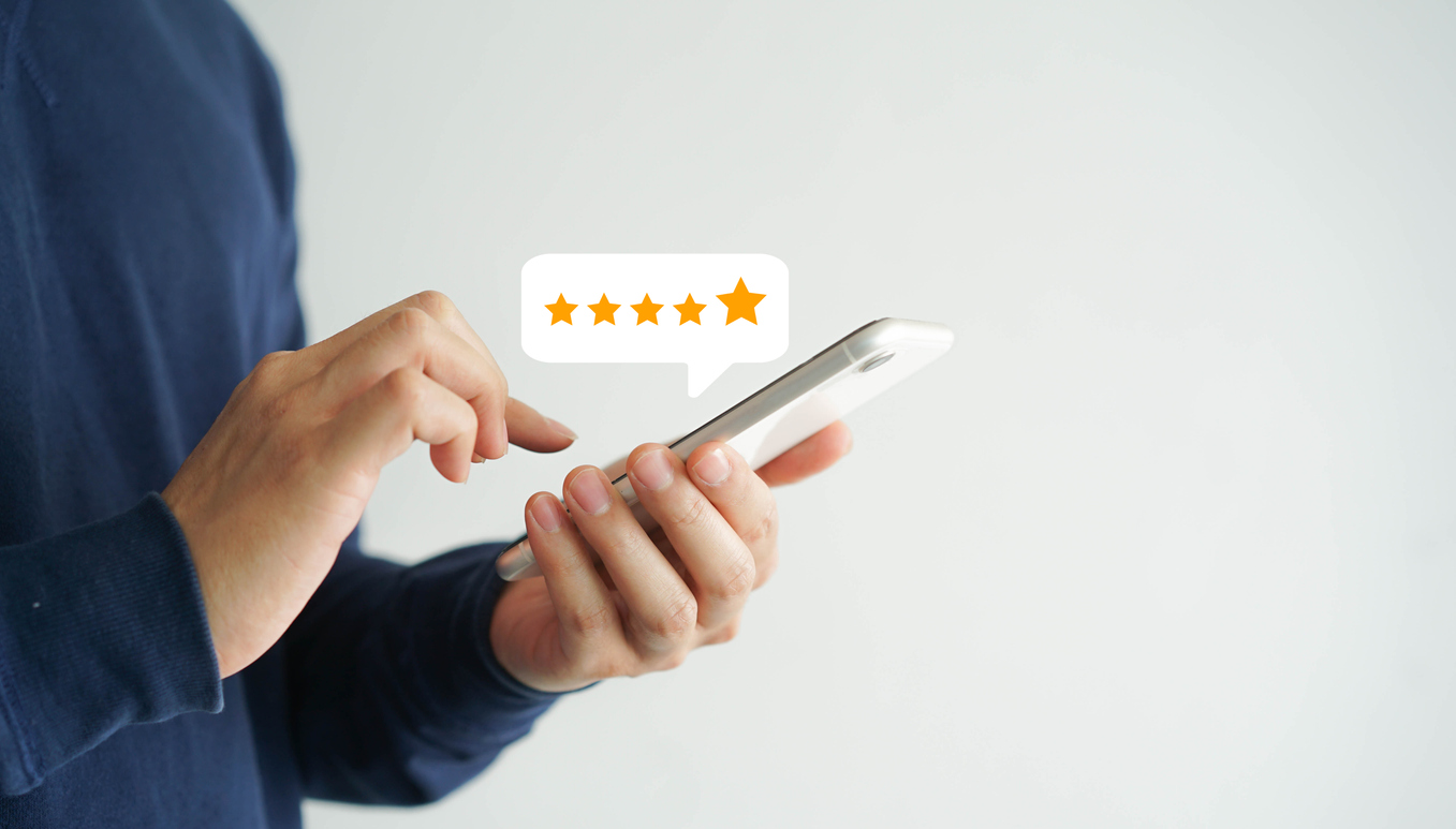 Model holding a smartphone and typing a review with a 5 star review bubble popping out of the phone