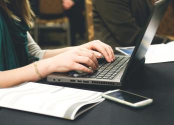 Close up of a person typing o their laptop