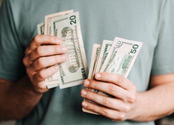 Close up on person holding multiple dollar bills