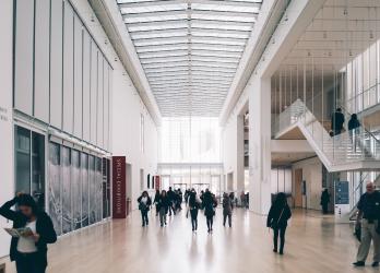 A crowd of people walking around a spacious office lobby