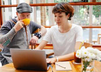 Two young business owners meet in a. coffee shop for a strategy meeting 