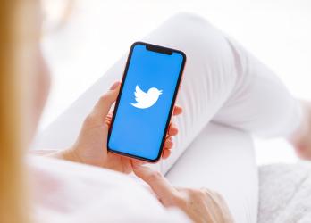 woman uses mobile smart phone to log onto Twitter