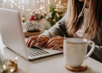 How Paid Ads Can Drive Traffic To Your Thanksgiving Offers with Marketer On a Laptop Working Around Holiday Promotional Times